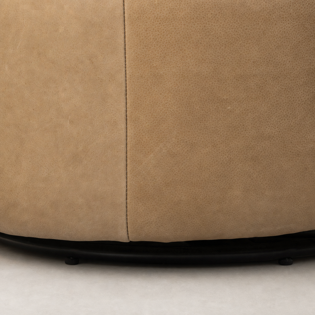 Misha Swivel Chair in Palermo Drift shows textured, soft leather detailing and sleek black base.