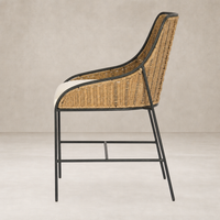 Side view of Savile Flax dining chair with woven rattan seat and black metal frame.