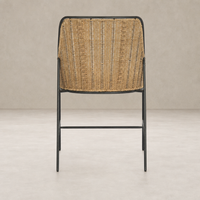 Back view of a Savile Flax dining chair with a woven seat and black metal frame.