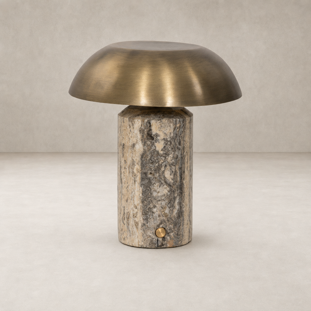 Cordless table lamp in aged antique brass iron with a cylindrical base.