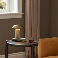 Cordless table lamp in aged antique brass iron with a sleek, modern design.