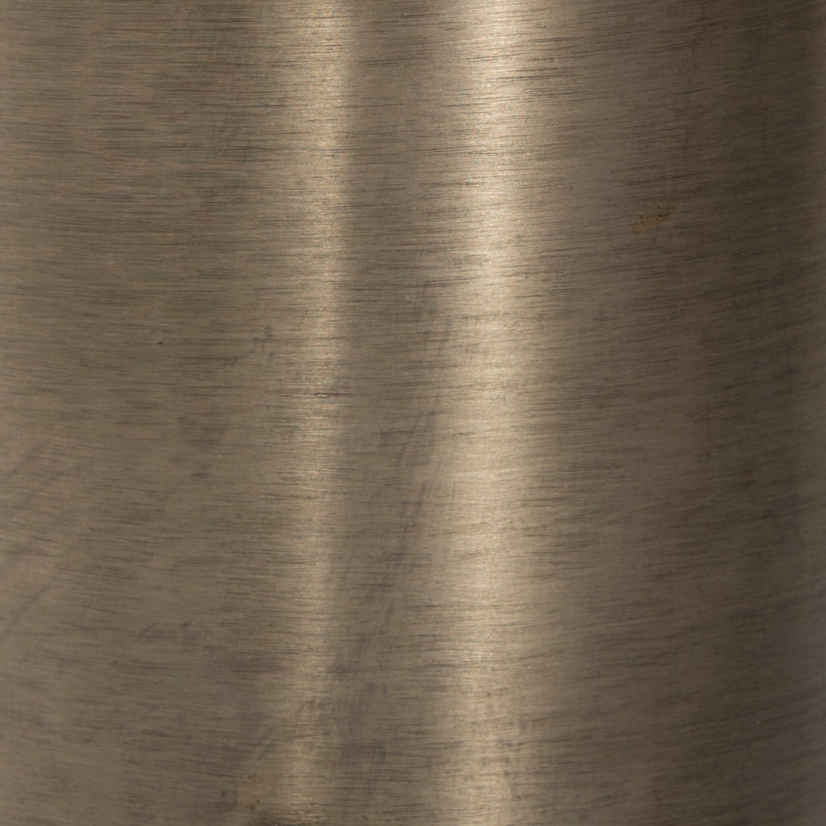 Close-up of the brushed surface of an antique nickel cordless table lamp.