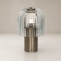 Cordless table lamp with a ribbed glass shade and antique nickel base.