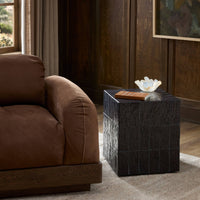Textured brown tile end table beside a cozy brown sofa in a stylish room.