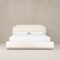 Elegant bed in Laughlin Bone upholstery with curved headboard and minimalist design.