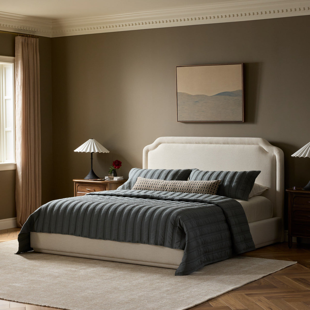 Elegant Laughlin Bone bed with a curved headboard and cozy layered bedding.