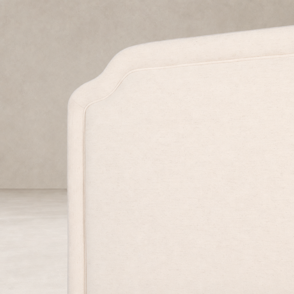 Elegant bed with a soft Laughlin Bone fabric and curved headboard design.