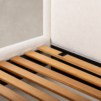 Close-up of wood slats supporting a Laughlin Bone bed frame with padded headboard.