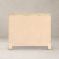 Natural Fleck Raffia nightstand with a textured surface and simple design.