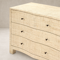Natural Fleck Raffia nightstand with curved edges and three drawers.