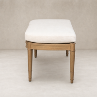 Accent bench with a soft Crypton Nomad Snow cushion and light wood legs.