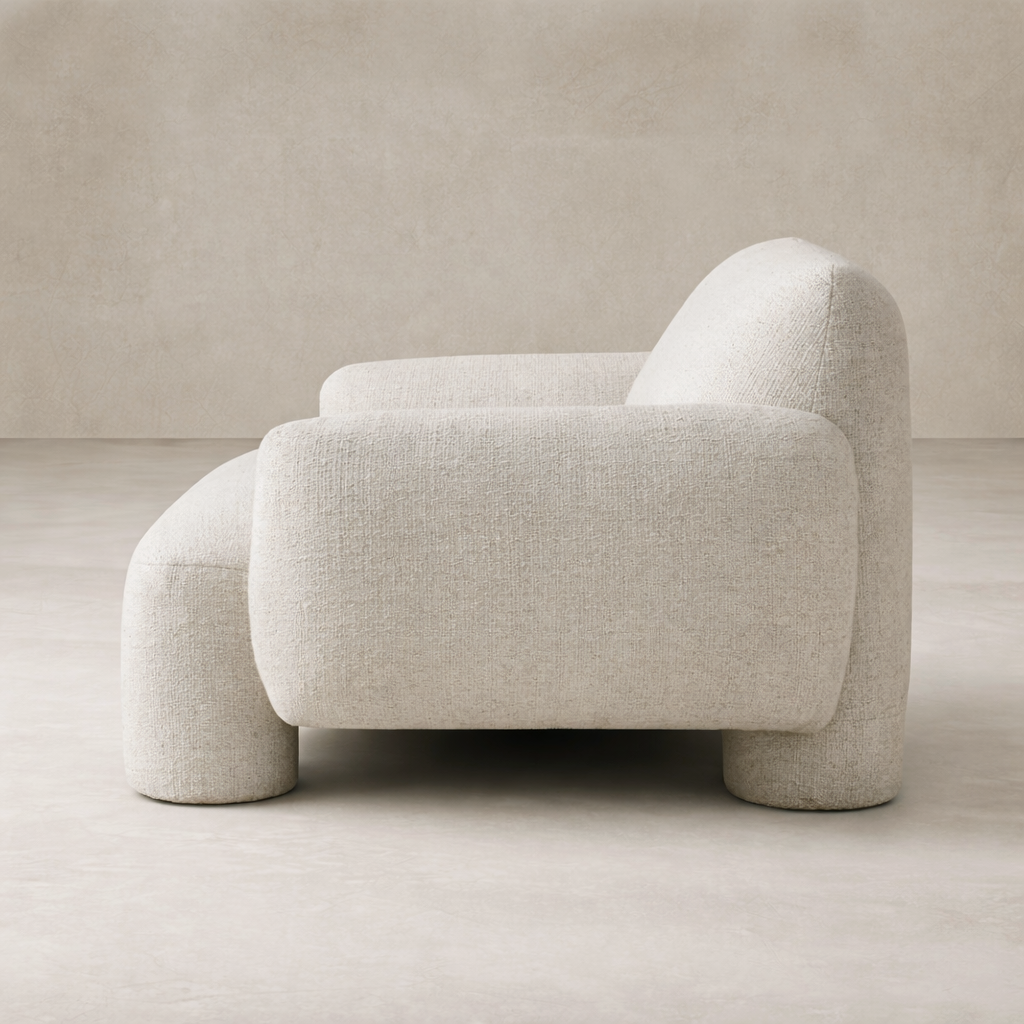 Side view of the Elba Accent Chair showcasing its soft, rounded design and textured fabric finish.