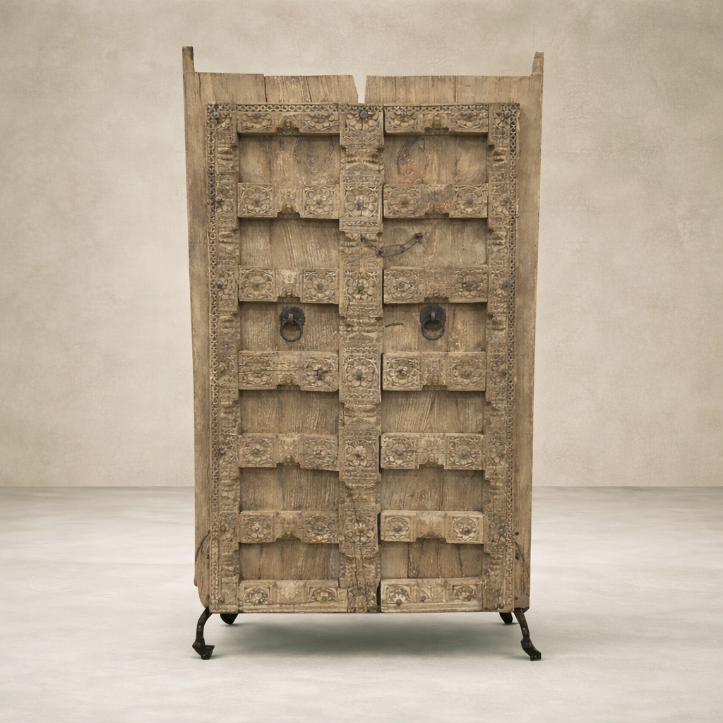 Front view of vintage Haveli doors on a stand, showcasing intricate carvings and rustic wood finish.