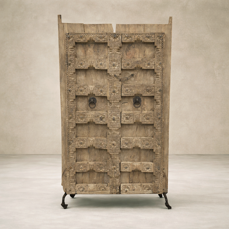 Front view of vintage Haveli doors on a stand, showcasing intricate carvings and rustic wood finish.