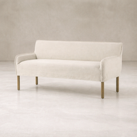 Slipcovered upholstered bench in cream fabric with a low back and wood legs.