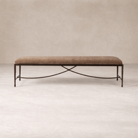 Long upholstered bench with a warm brown cushion and hand-forged iron base