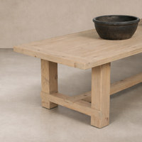 Close-up of the Verona Weathered Pine Dining Table, showcasing its rustic wood finish and sturdy legs.
