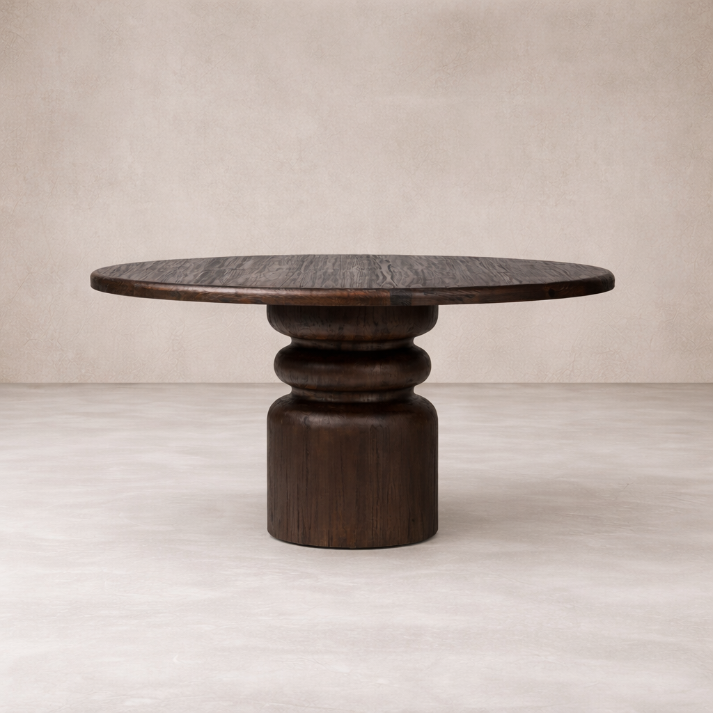 Front view of the Ravello Round Dining Table, featuring a dark wood finish and a sculptural pedestal base.