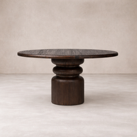 Front view of the Ravello Round Dining Table, featuring a dark wood finish and a sculptural pedestal base.