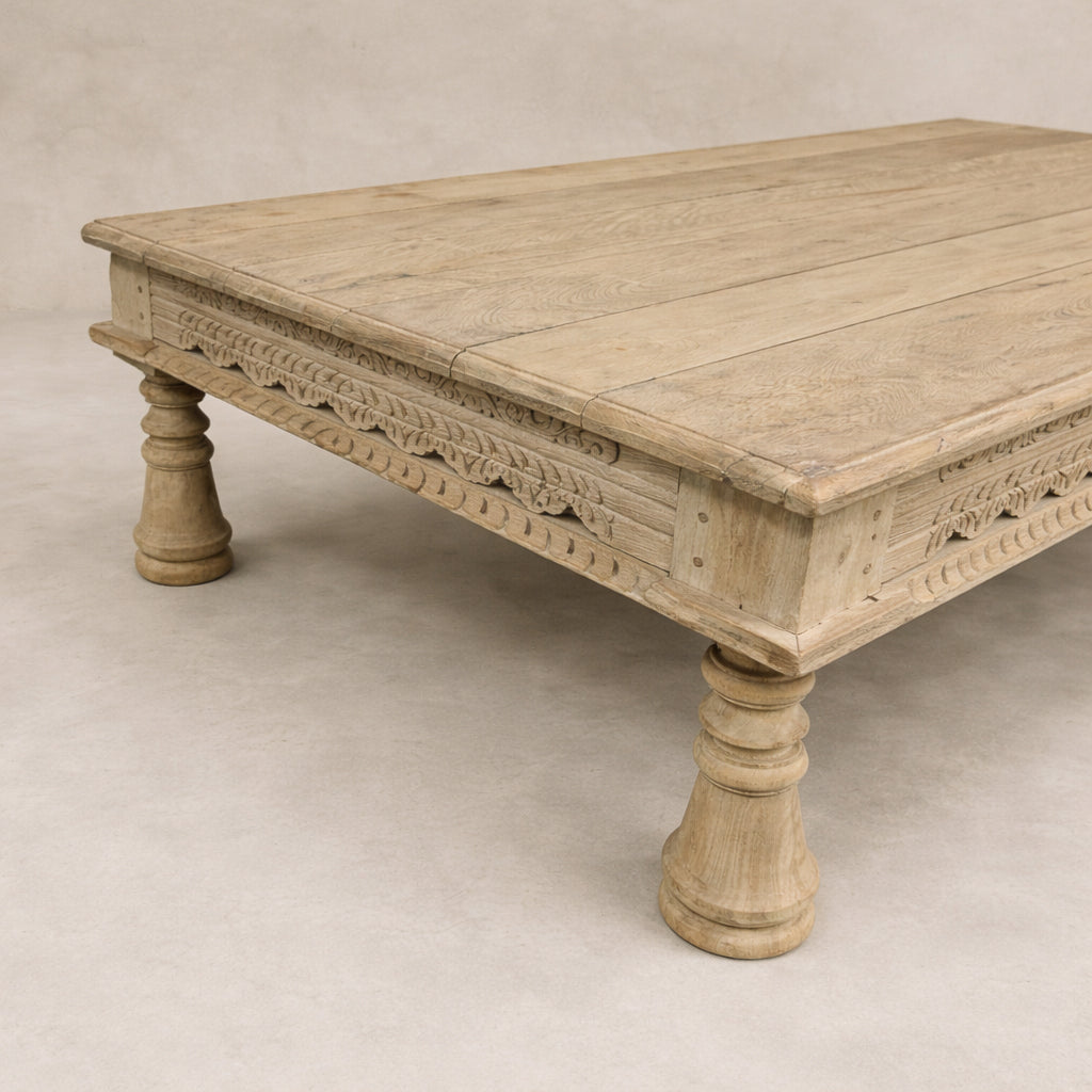 Side angle of the Dharma Vintage Takhat Coffee Table showcasing intricate carvings and a rustic finish.