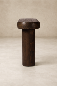 Front view of the Maelle Console Table featuring a rounded top and sturdy cylindrical base in rich dark wood.