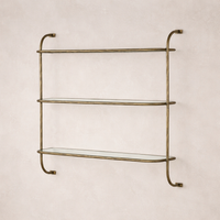 Close-up of the Winslow Shelf featuring elegant glass shelves and a textured brass frame.