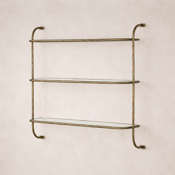 Close-up of the Winslow Shelf featuring elegant glass shelves and a textured brass frame.