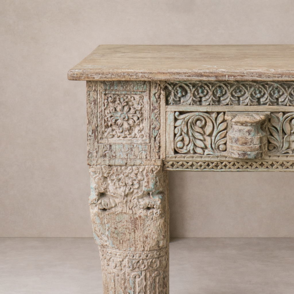 Detail of the Adana Carved Vintage Console Table showcasing intricate floral carvings and a weathered finish.