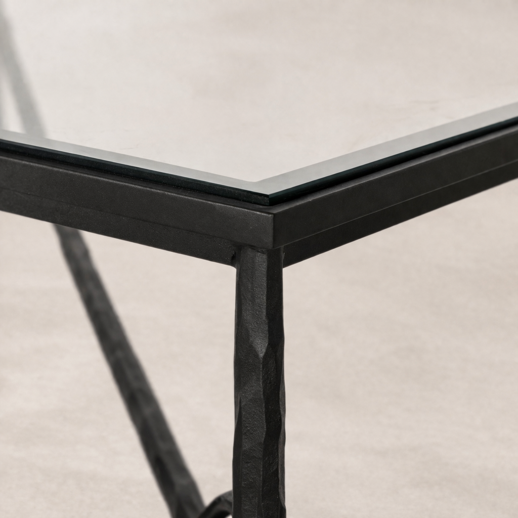 Close-up of the Selene Coffee Table highlighting its textured black metal frame and sleek glass top.
