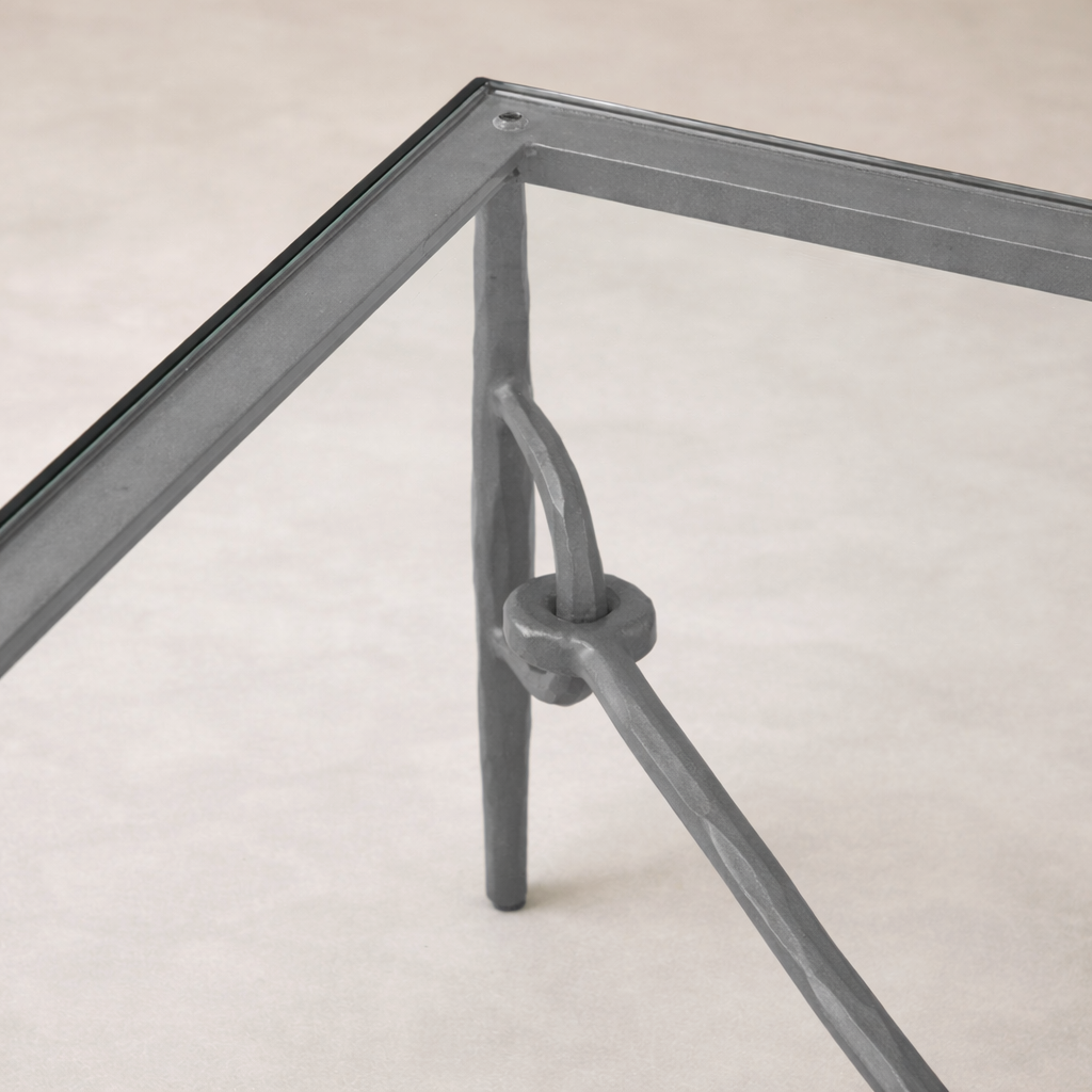 Detail of the Selene Coffee Table showcasing its sleek glass top and unique metal frame design.