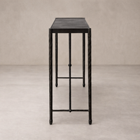 Side view of the Blythe Console Table showcasing its sleek black finish and elegant, textured legs.