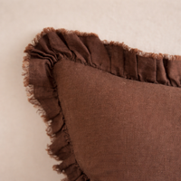 Detail of the Hallie Ruffled Linen Pillow in dark brown, showcasing its textured ruffled edge.