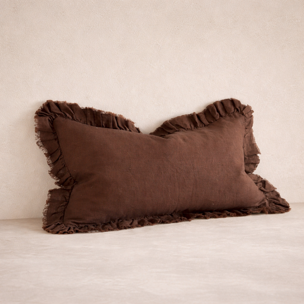 Detail of the Hallie Ruffled Linen Pillow in dark brown, showcasing its textured ruffle edges and soft linen fabric.