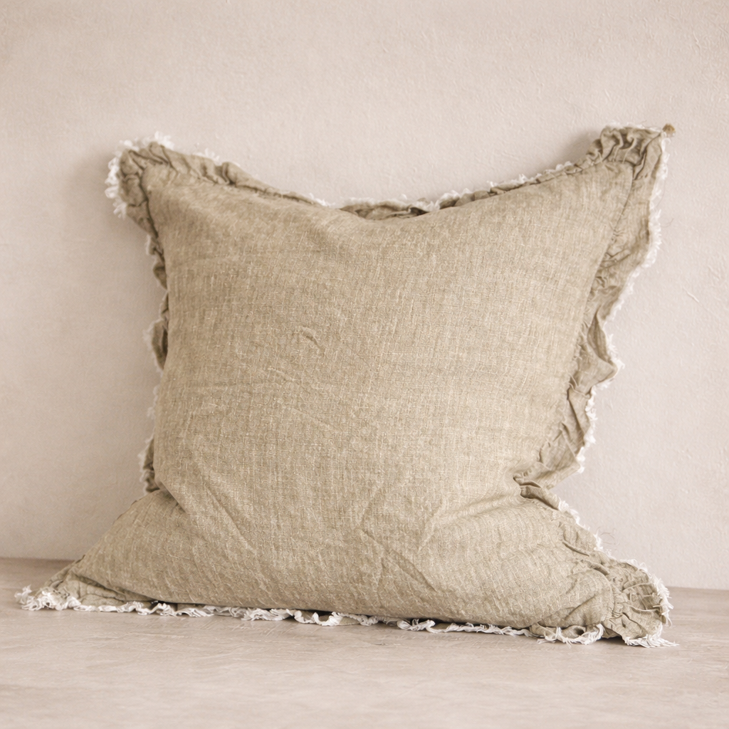 Close-up of the Hallie Ruffled Linen Pillow in Washed Olive, highlighting its textured fabric and frayed edges.