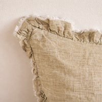 Detail of the Hallie Ruffled Linen Pillow in Washed Olive, highlighting its textured fabric and frayed edges.