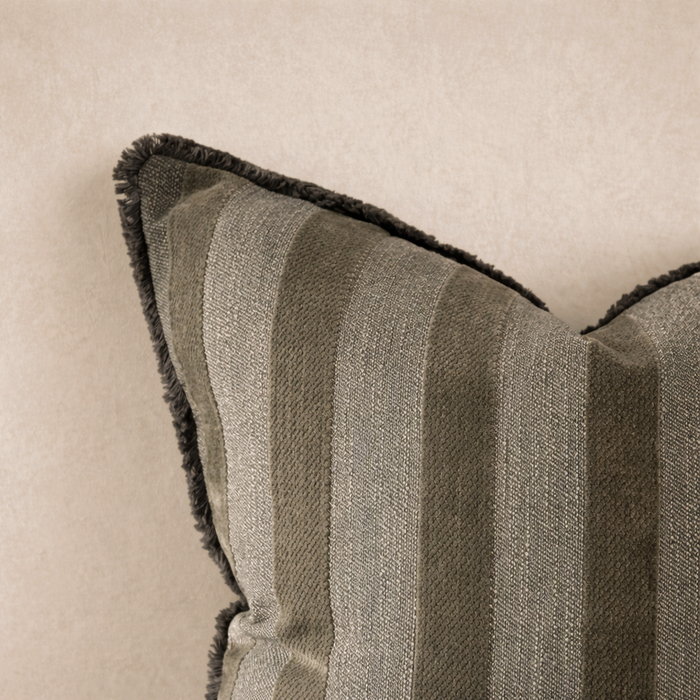 Close-up of the Isla Striped Pillow in Olive, featuring textured stripes and a plush fringe trim.