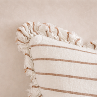 Detail of the Hallie Ruffled Linen Pillow showcasing soft brown and cream stripes with a ruffled edge.