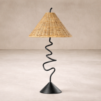 Side angle of the Anya Lamp featuring a woven conical shade and a sleek, twisted black metal base.