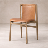 Side angle of Marbella Dining Chair showcasing its warm leather seat and rustic wooden frame.