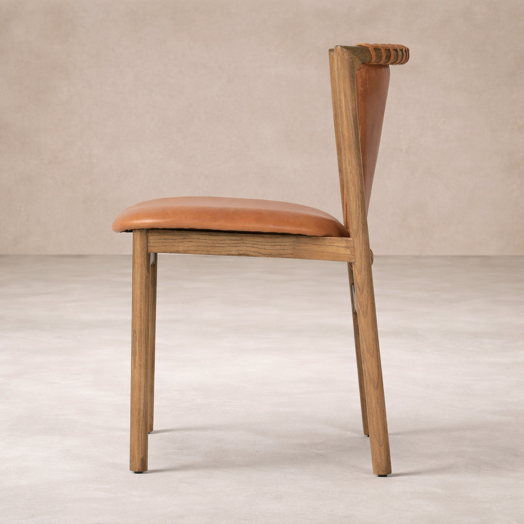 Side angle of the Marbella Dining Chair featuring a warm leather seat and sturdy wooden frame.