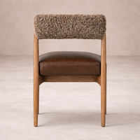 Side angle of the Calista Dining Chair featuring a brown leather seat and textured fabric backrest.