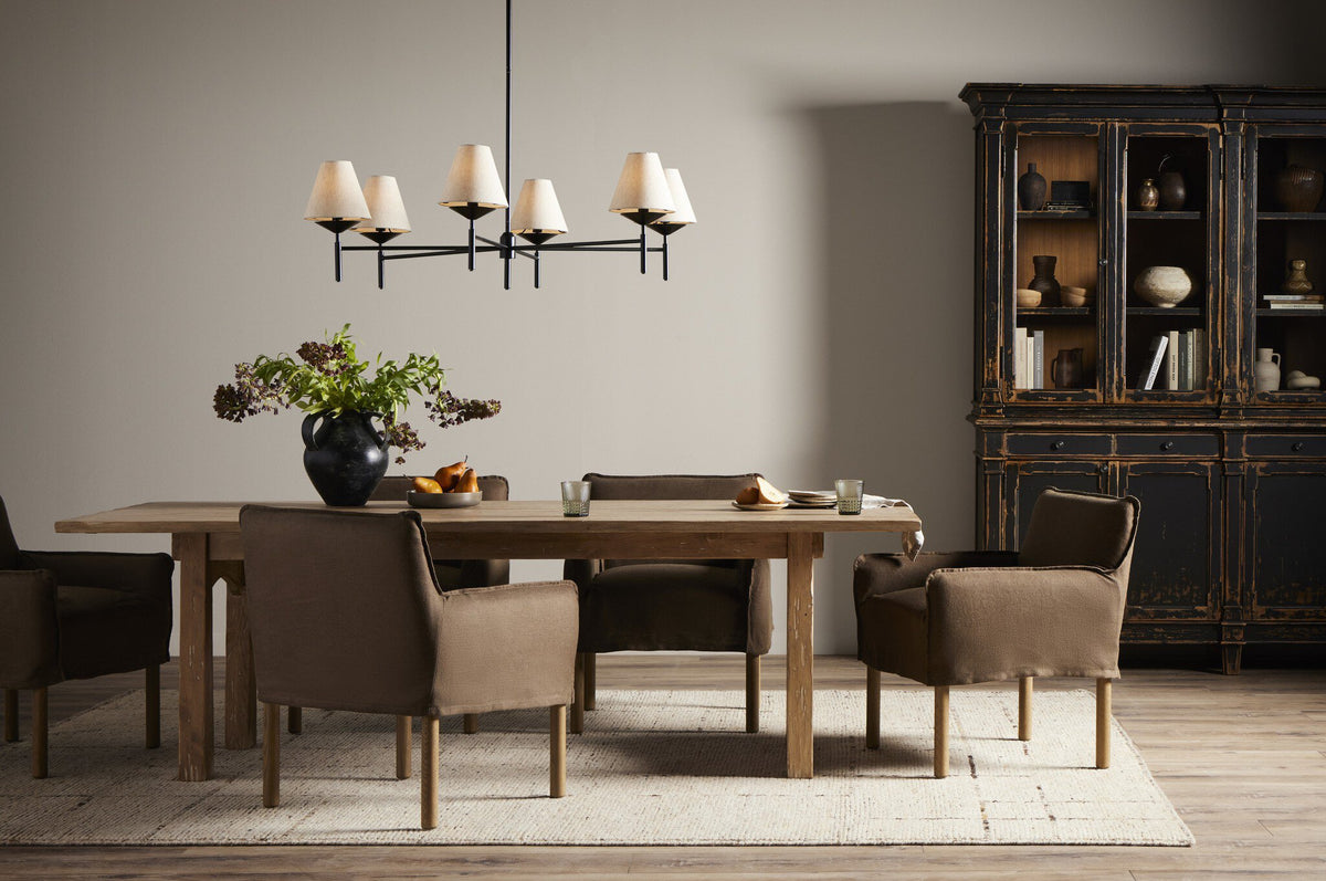 Dining room with wooden table, chairs, and a chandelier.