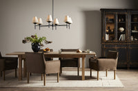 Dining room with wooden table, chairs, and a chandelier.