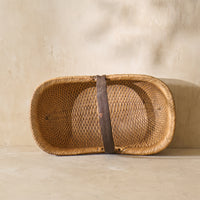 Top view of a vintage Shandong willow basket from the 1930s, showcasing intricate weaving and a rustic metal strap.