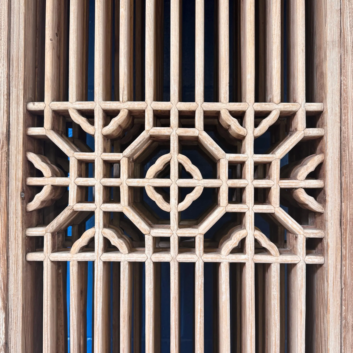 Detail of the Carved Elm Vintage Lattice Doors showcasing intricate woodwork and elegant geometric patterns.