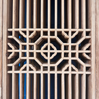 Detail of the Carved Elm Vintage Lattice Doors showcasing intricate woodwork and elegant geometric patterns.