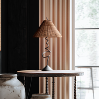 Close-up of the Anya Lamp featuring a woven shade and a sculptural metal base.