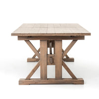 Front view of the Positano Extension Dining Table showcasing its rustic wooden finish and sturdy X-frame base.