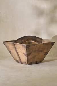 Detail of a vintage 19th-century rice bucket showcasing its rustic wooden construction and unique shape.