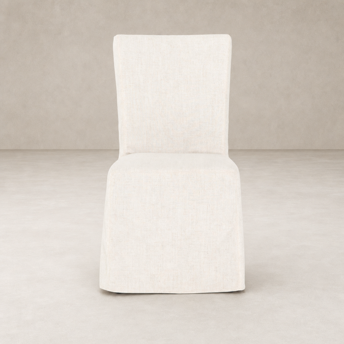 Sierra Slipcovered Dining Chair featuring a light, textured fabric in a minimalist design.
